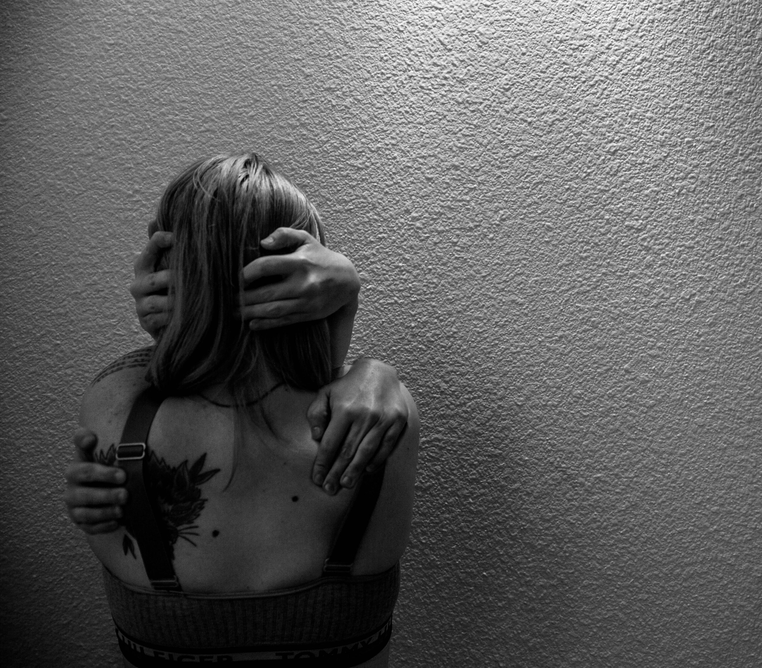 A girl hugging herself with an extra set of hands.