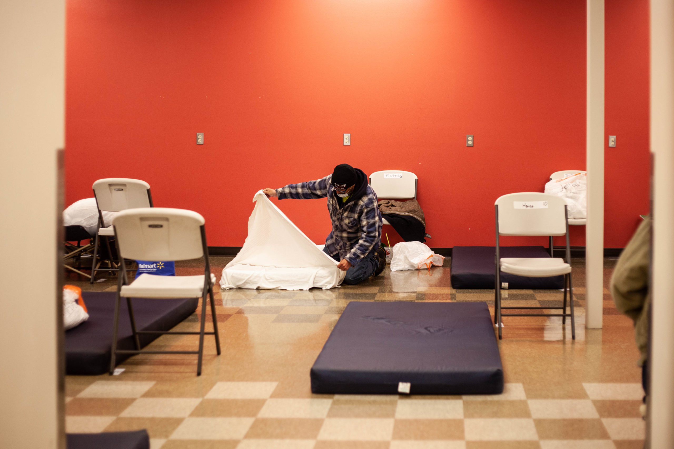 A man sets up his bed for the night at the Salvation Army.