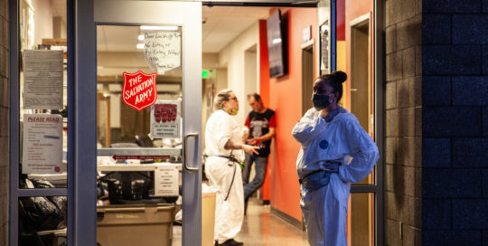 A woman waits outside for people to come back into the building of the Salvation Army