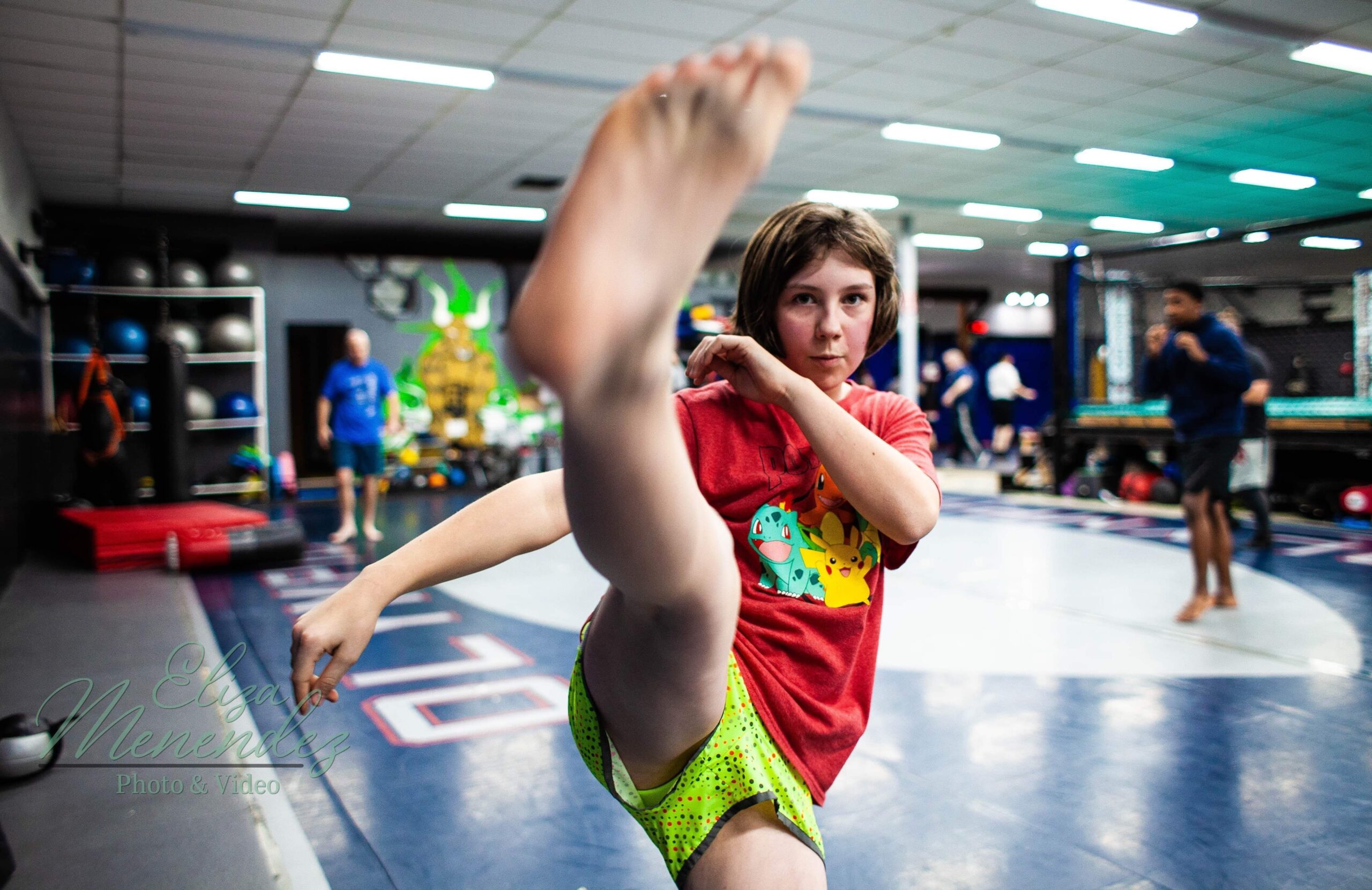 A little girl throws a kick in the Muay Thai class.